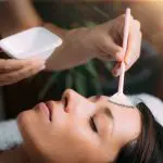 Esthetics student applying a cosmeceutical serum during hands-on training at Atelier Esthétique Institute in NYC