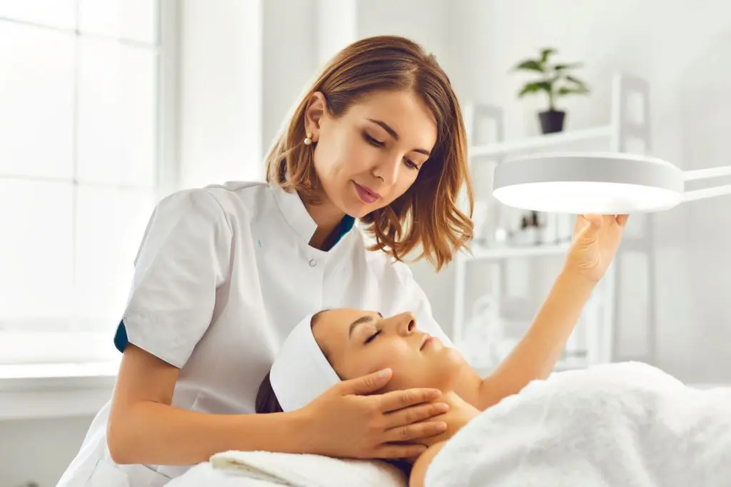 An esthetician providing a facial massage to an esthetics client