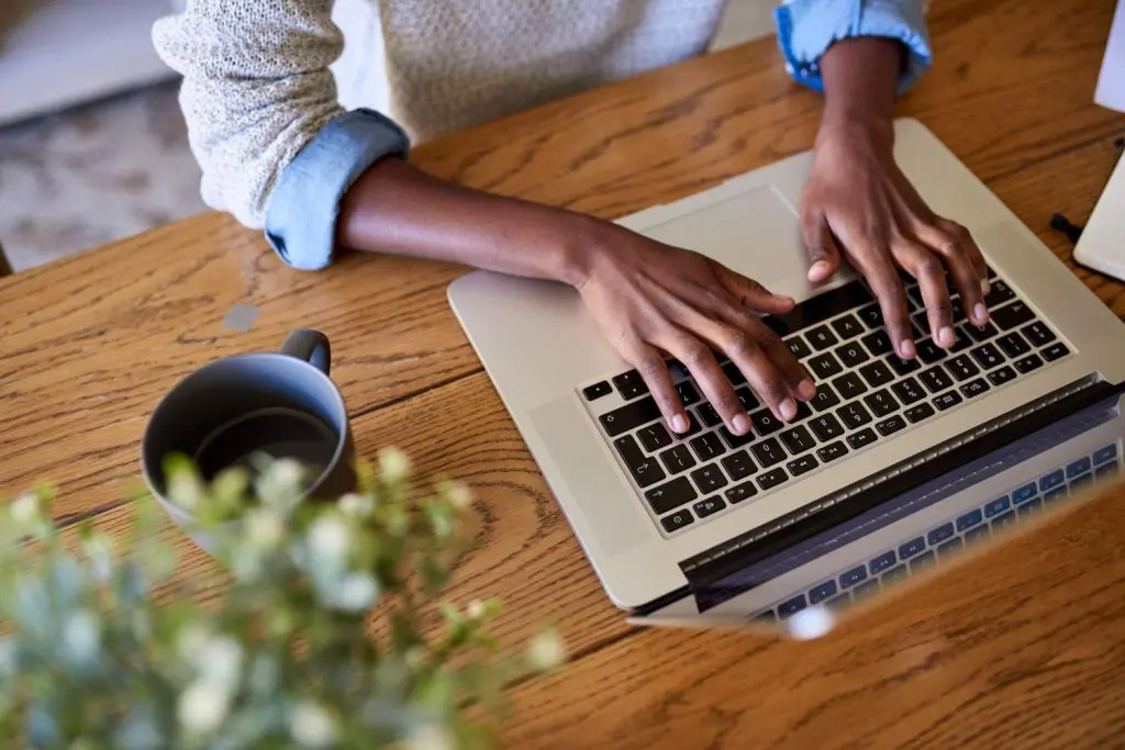 Student typing on a laptop at a desk