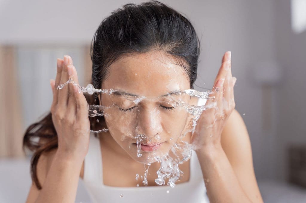Woman washing her face before a good chemical exfoliation session