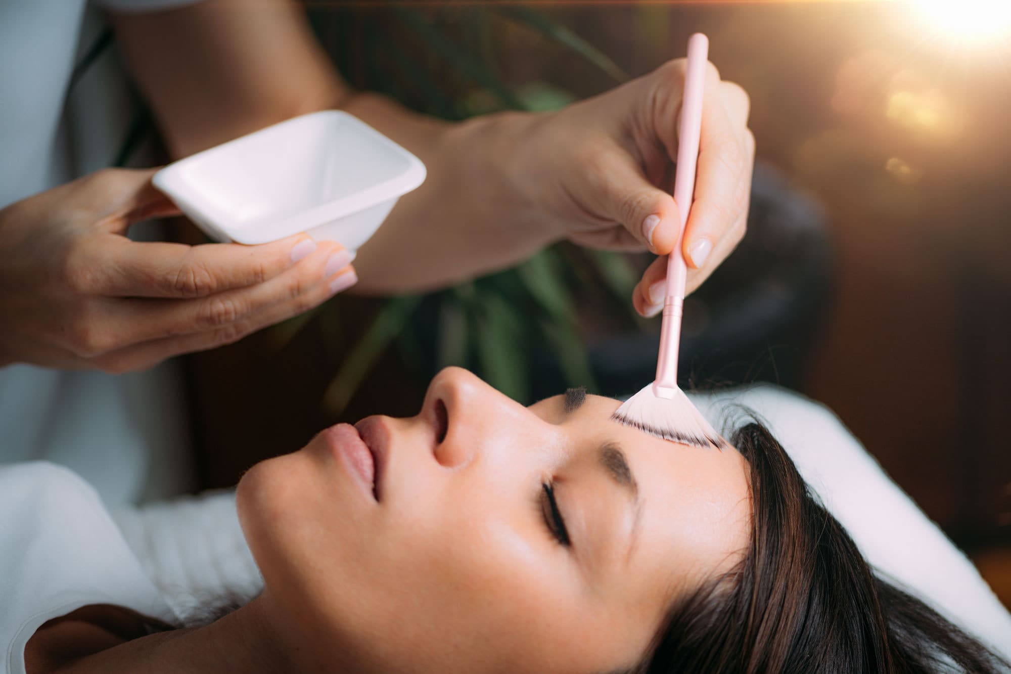Esthetics student applying a cosmeceutical serum during hands-on training at Atelier Esthétique Institute in NYC